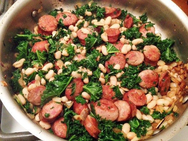 sausage, beans and kale in a pan on the stove