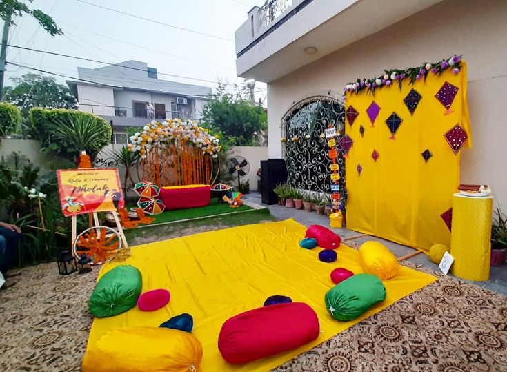 an outdoor area with yellow and red decorations on the ground, including balloons and pillows