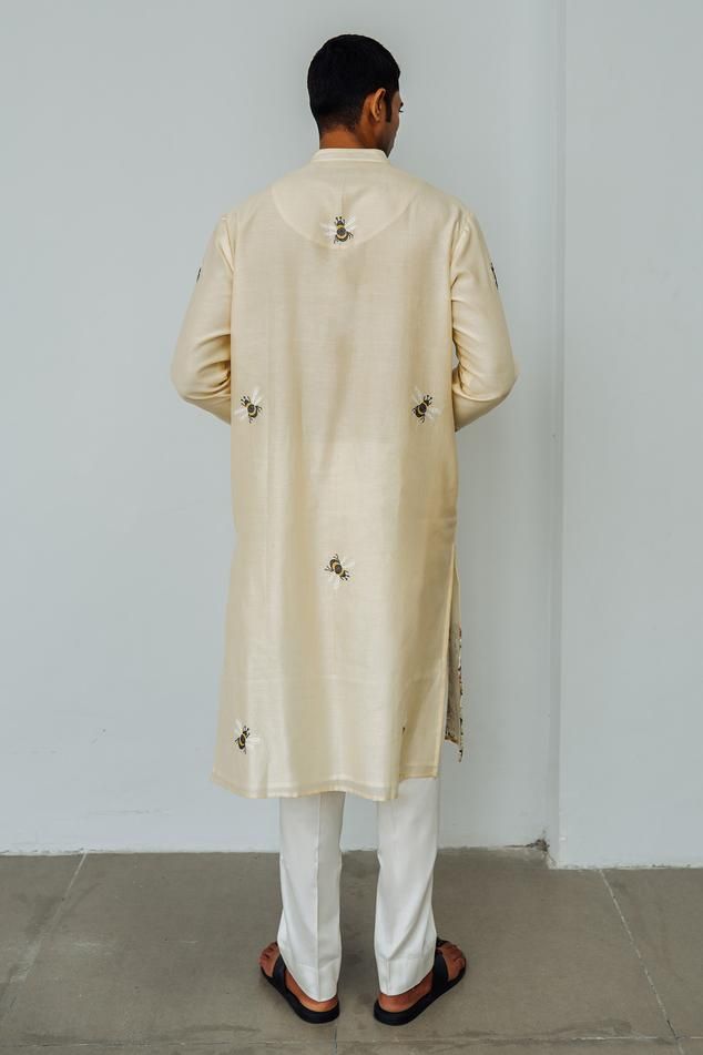 Beige long sleeves kurta in chanderi base with floral bumblebee aari embroidery and mandarin collar neckline. Paired with a plain straight pant.
Components: 2
Pattern: Embroidery
Type Of Work: Aari, Honey Bee
Neckline: Mandarin Collar
Sleeve Type: Long Sleeves
Fabric: Chanderi
Color: Beige
Other Details: 

Side slits
Closure: Front placket buttons
Occasion: Destination Wedding, Sangeet - Aza Fashions Raw Silk Bandhgala With Dabka Work And Long Sleeves, Long Sleeve Nehru Jacket With Dabka For Eid, Cotton Nehru Jacket With Zari Work And Long Sleeves, Traditional Long Sleeve Kurta With Naqshi, Semi-stitched Long Sleeve Churidar With Naqshi, Cotton Long Sleeve Bandhgala With Zari Work, Silk Sherwani With Dabka Work And Long Sleeves, Cotton Bandhgala With Zari Work And Long Sleeves, Traditional Long Sleeve Churidar With Naqshi