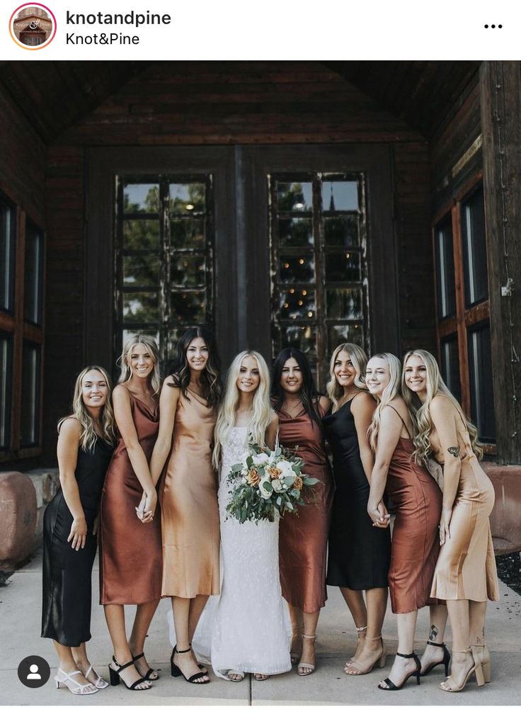 a group of women standing next to each other in front of a door wearing dresses