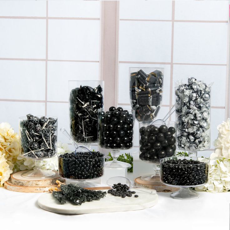 a table topped with lots of cakes covered in blackberries and white carnations