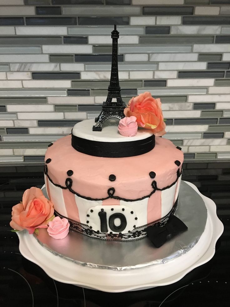 a pink and black cake with the eiffel tower on top