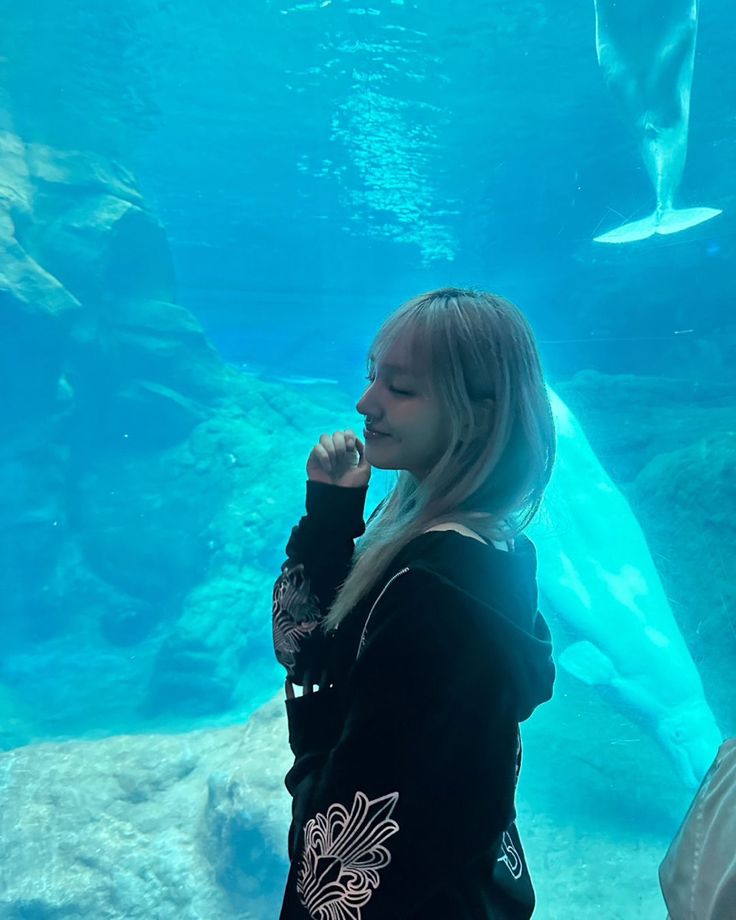 a woman standing in front of an aquarium tank