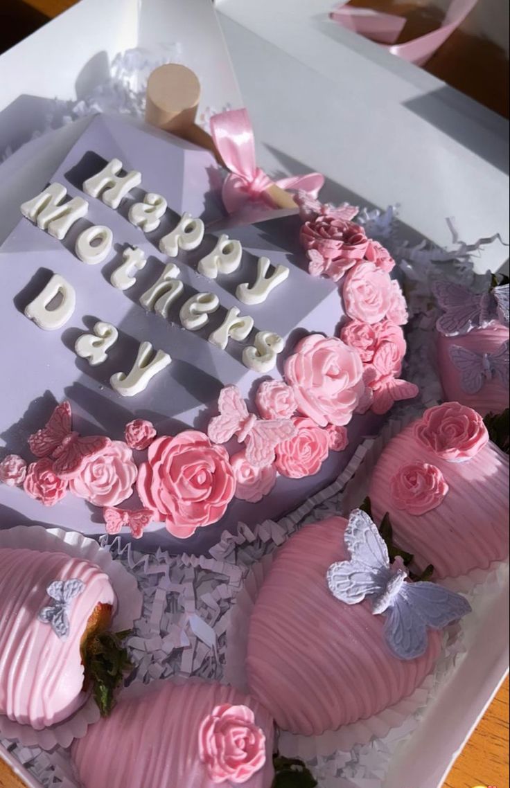 a birthday cake in a box with pink roses and butterflies on it's side