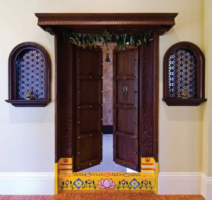 an open wooden door in the middle of a room with two windows on either side