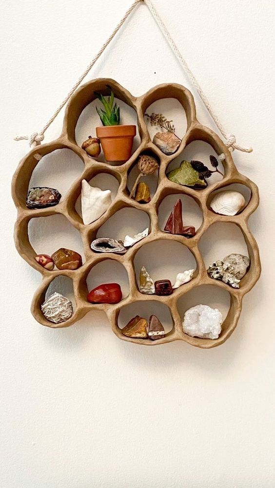 a wall hanging made out of wooden circles with various rocks and plants in the center