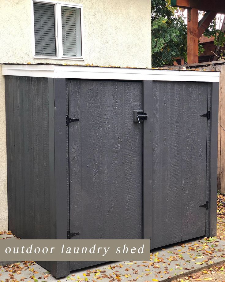 an outdoor laundry shed is shown in front of a house with leaves on the ground