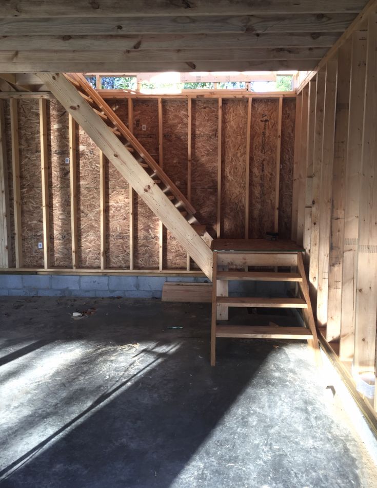 an unfinished room with wooden walls and stairs