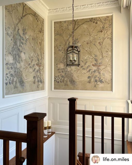 the wall paper is hanging on the wall behind the railing in this hallway with wood handrails