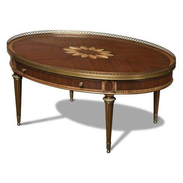 an oval wooden table with gold trimmings on the top and bottom, sitting in front of a white background