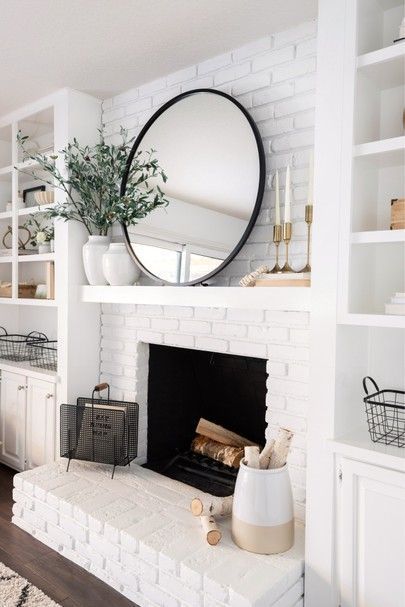 a living room filled with furniture and a fire place in front of a white brick fireplace