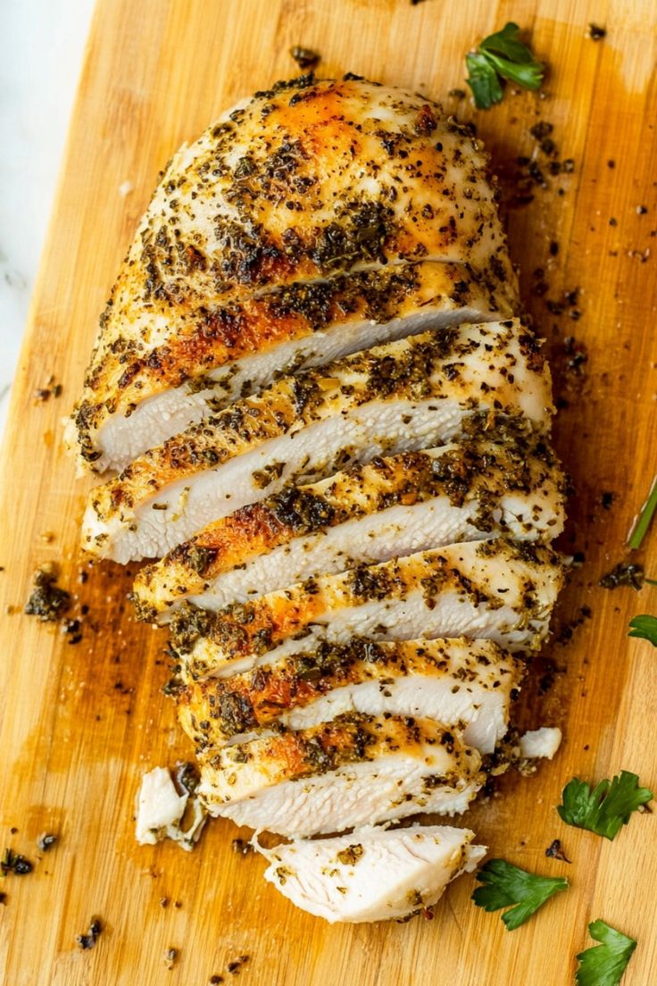 sliced chicken with herbs and seasoning on a cutting board