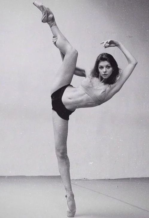 a woman in a leotard doing a dance pose with her legs spread out