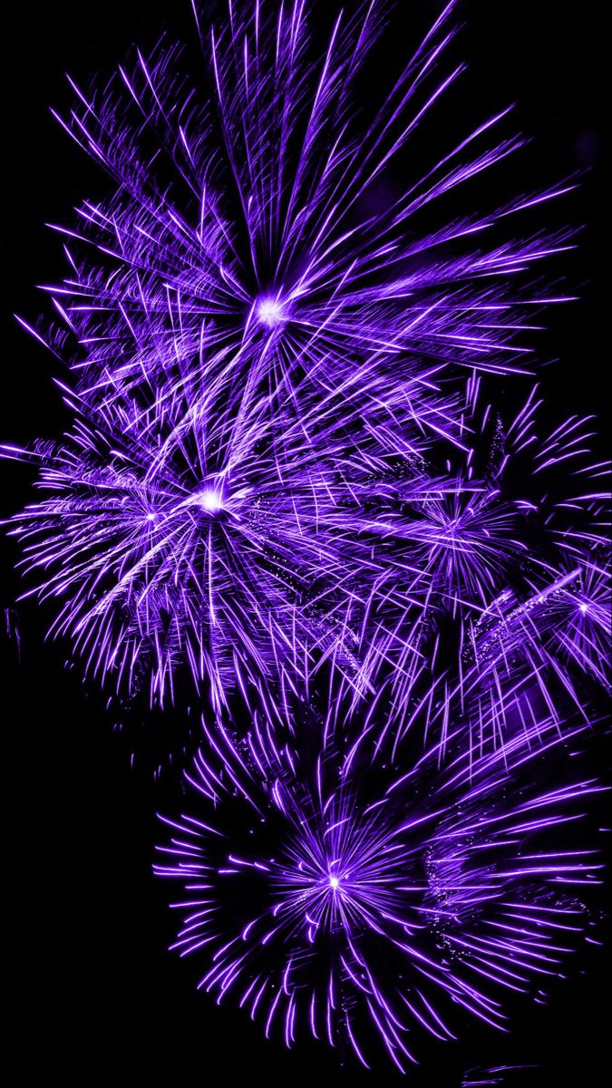 purple fireworks are lit up in the night sky