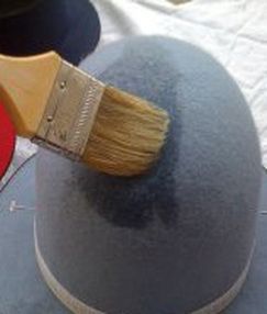 a hat with a paintbrush on top of it