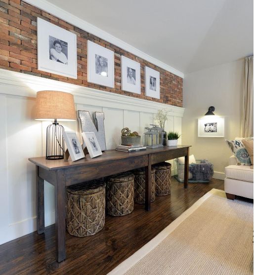 a living room with pictures hanging on the wall and two baskets under the coffee table