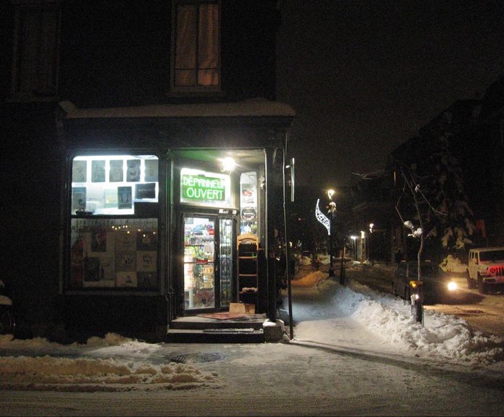 a bus stop sitting on the side of a road covered in snow next to a street light