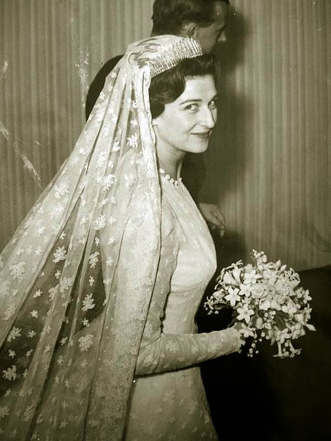 an old black and white photo of a woman in a wedding dress with a veil over her head