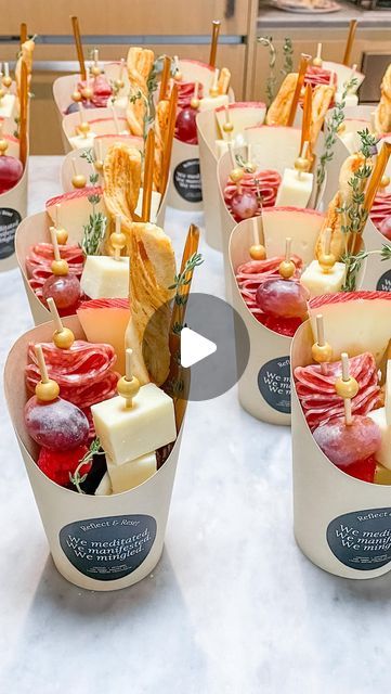 several cups filled with different types of food on top of a white tablecloth covered table