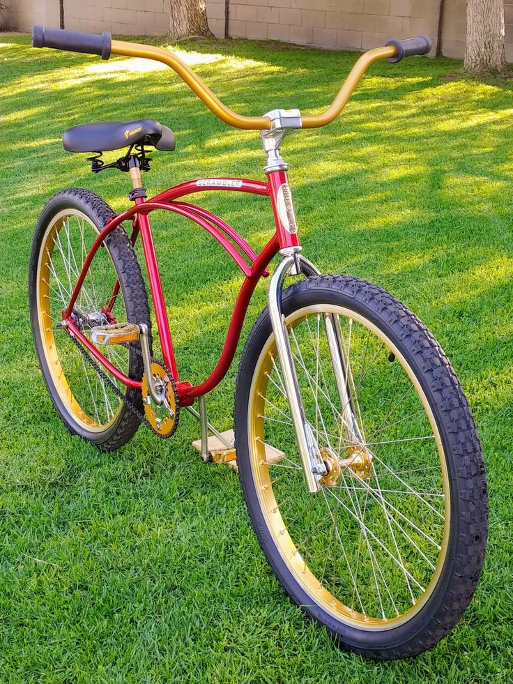 a red and yellow bicycle parked on the grass