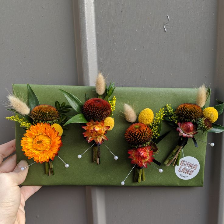 flowers are arranged on a green board in front of a door