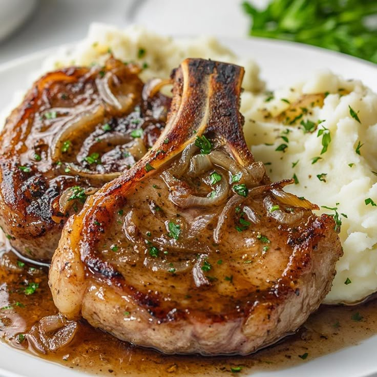 some meat and mashed potatoes on a white plate