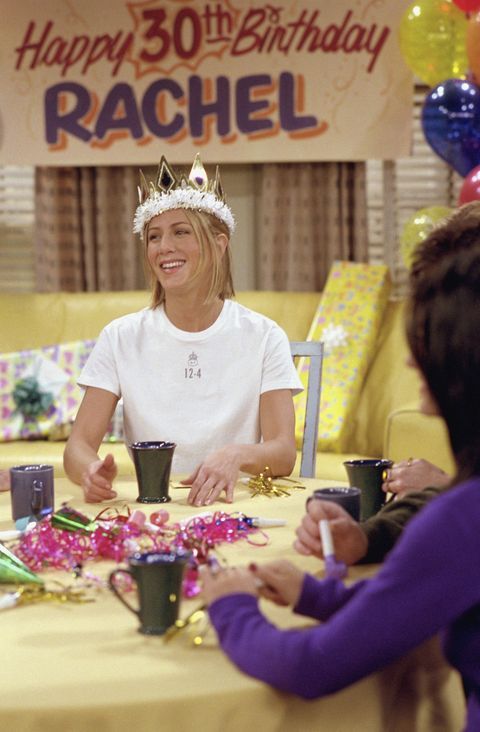 two women sitting at a table with cups and confetti in front of them