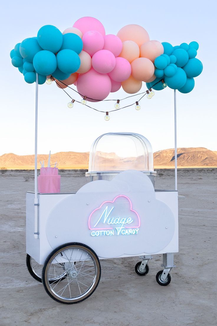 an ice cream cart with balloons attached to it