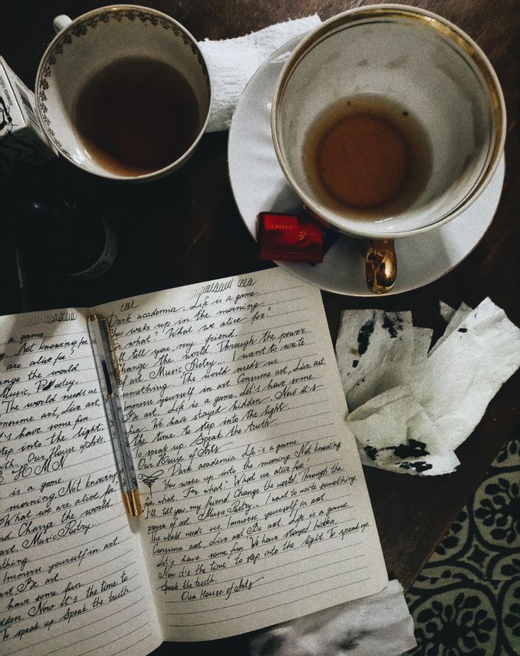 two cups of coffee and an open notebook on a table