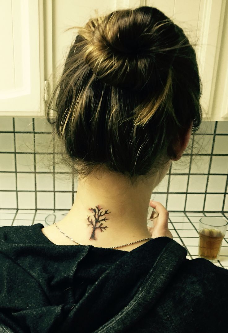 a woman with a tree tattoo on her neck