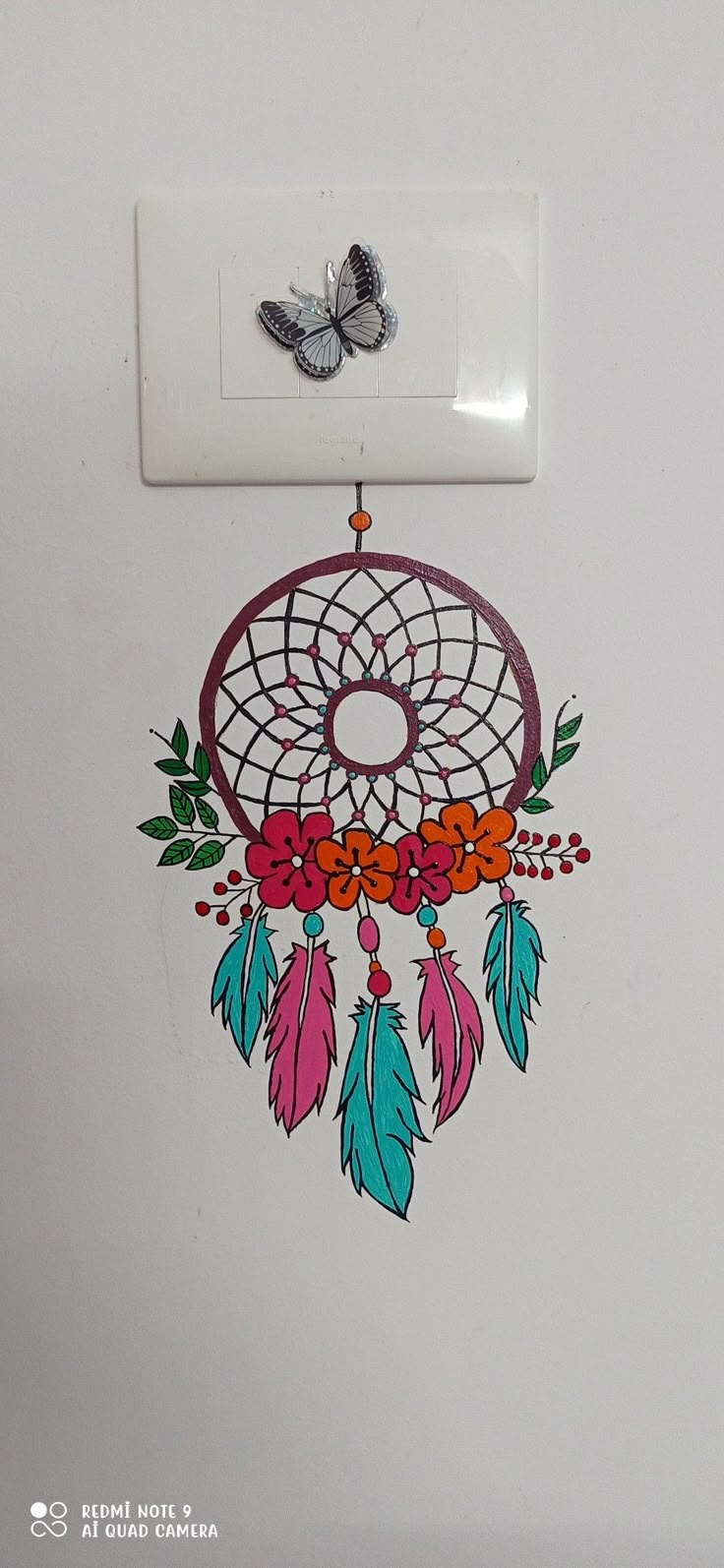 a drawing of a dream catcher hanging on the wall next to a light switch plate