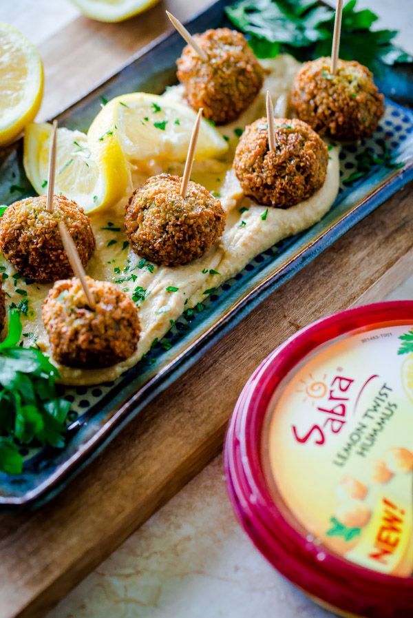 there are some appetizers on a tray with lemons and parsley