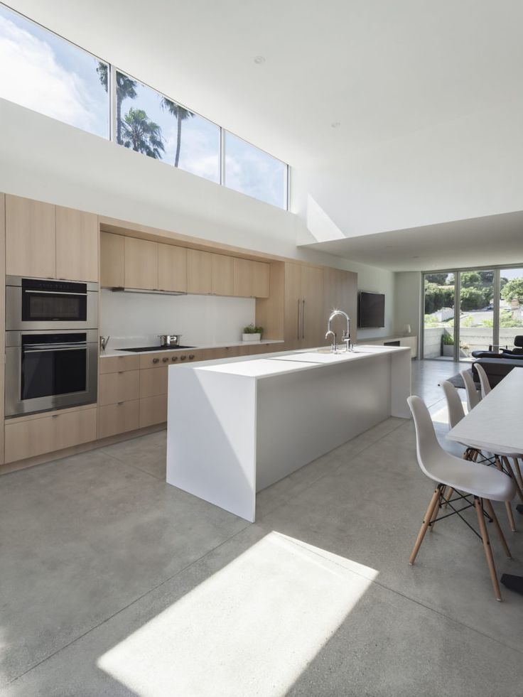 an open kitchen and dining room with large windows