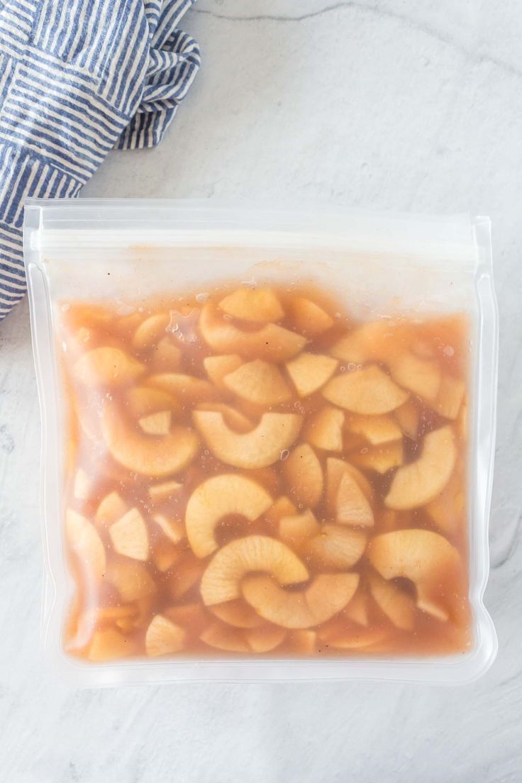 a plastic bag filled with sliced bananas sitting on top of a white marble countertop