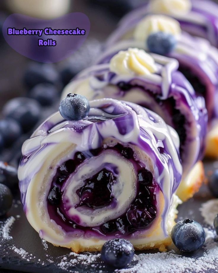 blueberry cheesecake rolls with icing drizzled over them