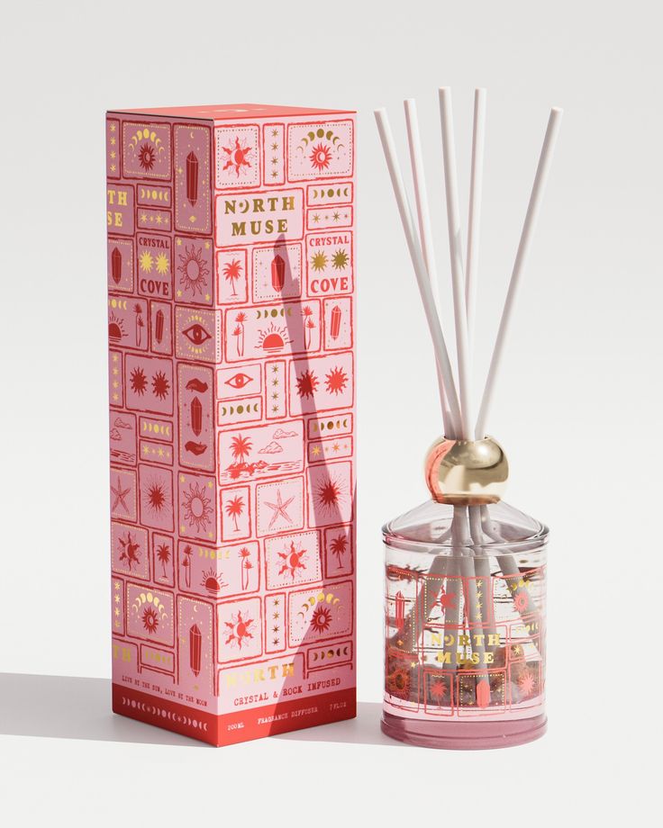 a pink box and reed diffuser next to it