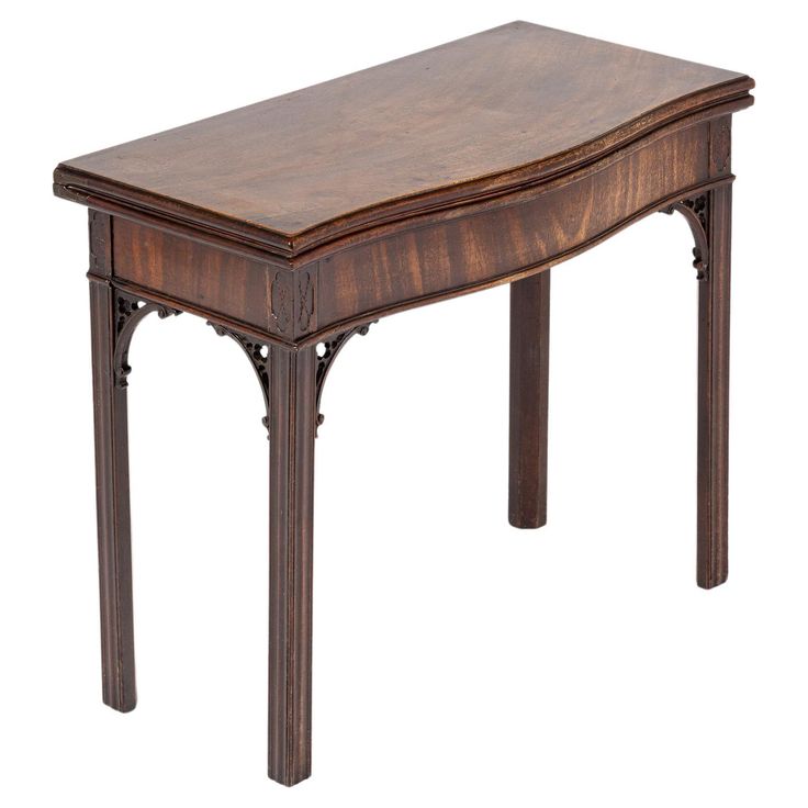 a wooden table with an ornate design on the top and bottom edge, against a white background