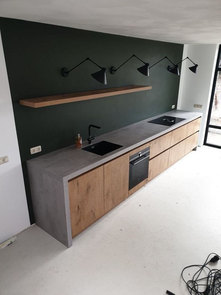 a kitchen with an oven, sink and some lights on the wall above it's counter