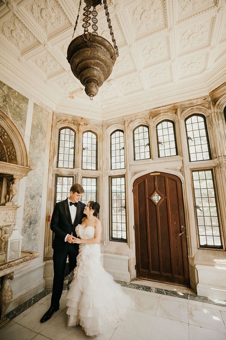 a bride and groom standing in front of an ornately decorated entrance to their wedding venue