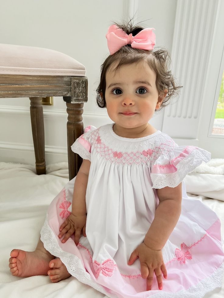 Sweet White Dress With Floral Embroidery, White Embroidered Dress For Playtime, Cute Floral Embroidery Dress For Playtime, Fitted Baptism Dress With Bow, Pink Embroidered Dresses For Baptism, Pink Embroidered Dress For Baptism, White Dress With Bow For First Birthday, Summer Baptism Dress With Bow Detail, Pink Floral Embroidery Dress For Baptism