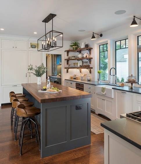 a large kitchen with an island in the middle and lots of lights hanging from the ceiling