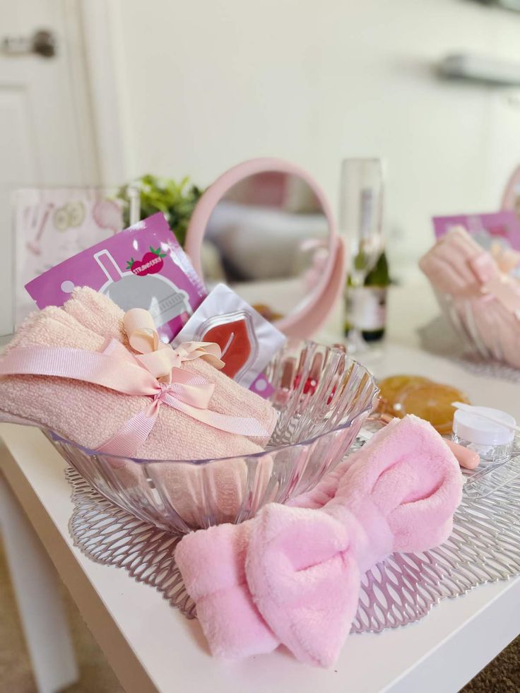 a glass bowl filled with pink items sitting on top of a table next to other items