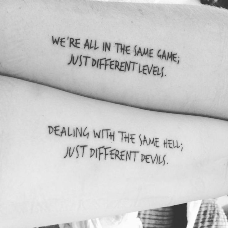 two people with tattoos that say we're all in the same game, just different level