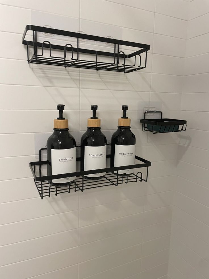 three bottles of soap and lotion are hanging on the wall