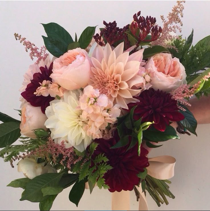 a bouquet of flowers is being held by someone's hand