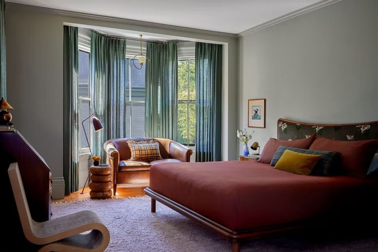 a bed sitting next to a window in a bedroom