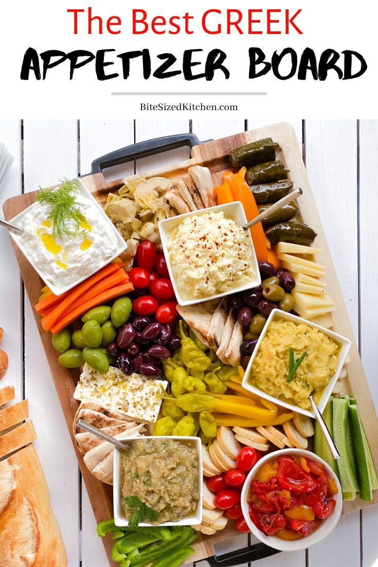 the best greek appetizer board with vegetables, dips and crackers on it