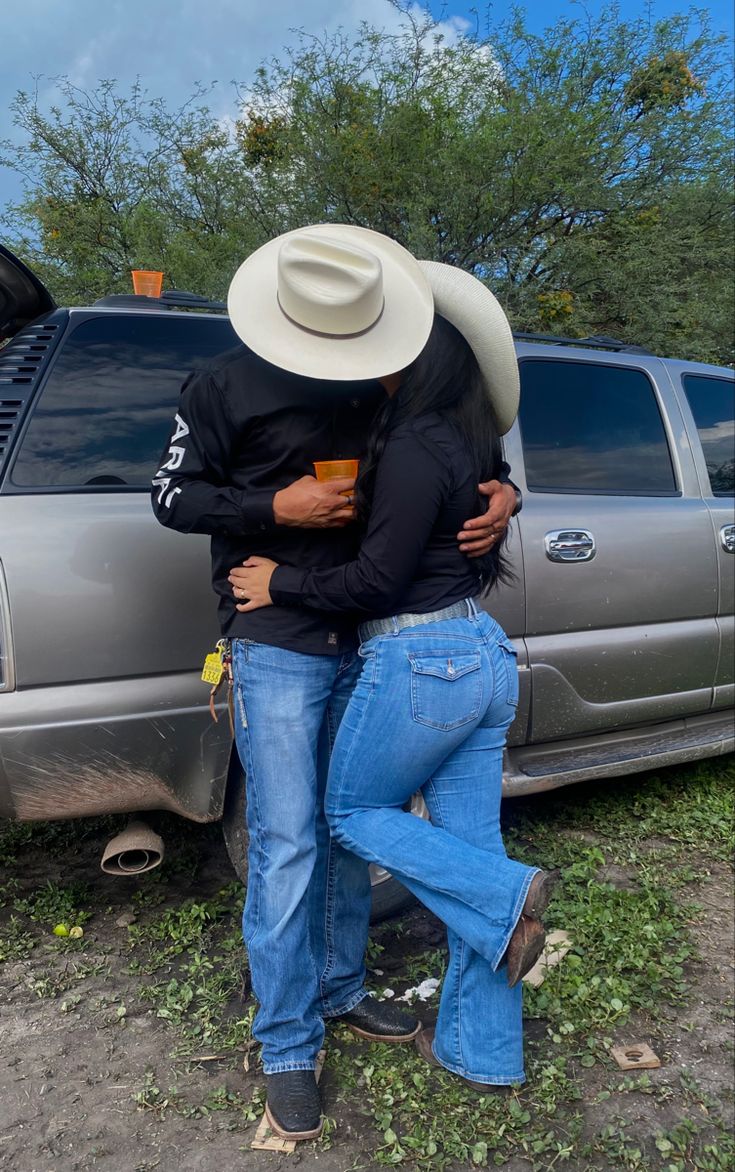 two people hugging each other in front of a truck