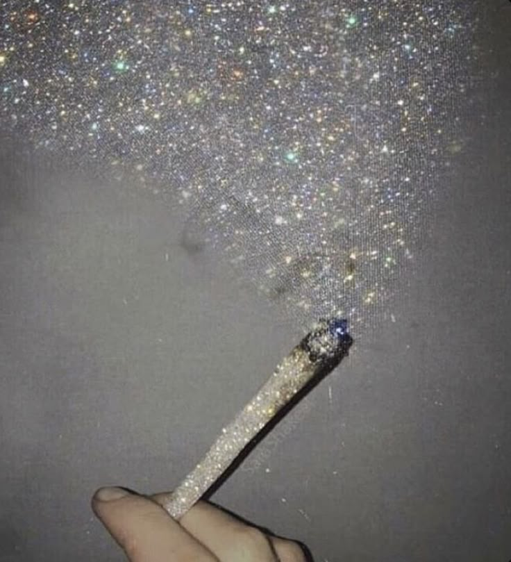 a person holding a sparkle wand in their hand