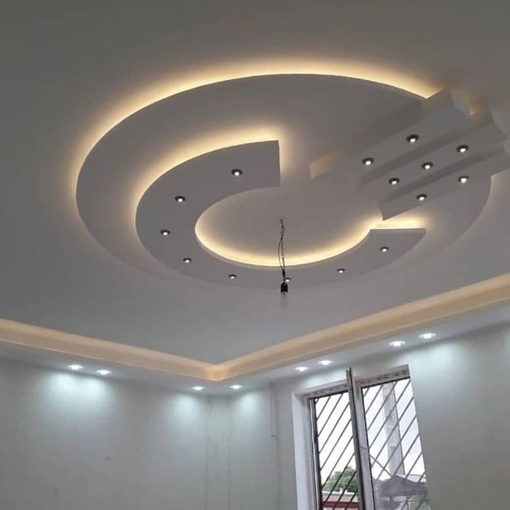 an empty room with white walls and lights on the ceiling is lit by recessed lighting